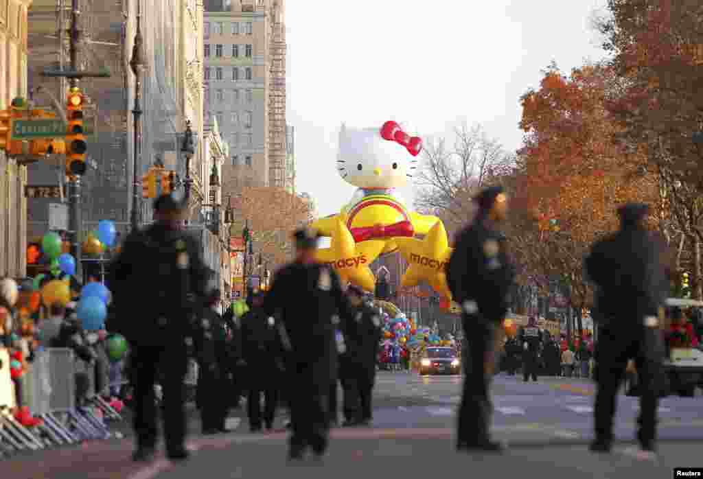 2012年11月22日,警察走在纽约中央公园西侧,同时,Hello Kitty气球等待着梅西第86届花车游行的开始。