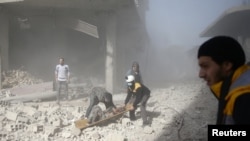 FILE - Civil defense members and civilians carry a wounded man in the town of Hamoria, Eastern Ghouta, near Damascus, Syria, Dec. 3, 2017.