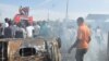 People gather at the scene of a car bomb explosion at the central market, Maiduguri, Nigeria, July 1, 2014. 