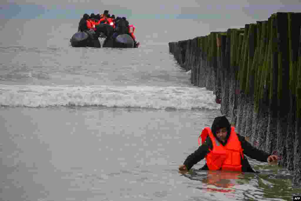 A migrant returns to shore after attempting to cross the English Channel to reach Great Britain on a smuggler's inflatable dinghy at Sangatte beach near Calais, northern France.