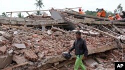 Un hombre que perdió su casa y algunos familiares camina junto a los escombros de un edificio derrumbado por el sismo que sacudió la ciudad de Cianjur, en Indonesia, el 22 de noviembre de 2022.