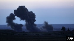 Smoke billows from the embattled village of Baghouz in the northern Syrian Deir Ezzor province on Feb. 19, 2019 during air strikes by the US-backed coalition against the Islamic State group.