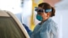 Medicinska sestra u Sijetlu, vrši testiranje pacijenata u kolima, u prolazu ispred Kliničkog centra Univerzteta Vašington (Foto: Reuters/Lindsey Wasson)