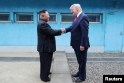 FILE - U.S. President Donald Trump shakes hands with North Korean leader Kim Jong Un as they meet at the demilitarized zone separating the two Koreas, in Panmunjom, June 30, 2019. (KCNA via Reuters)