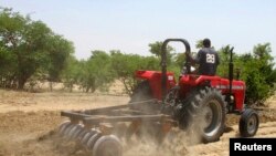 Wani manomi yana hudar gonarsa da motar tarakta a Kaduna Najeriya.