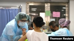 A nurse administers a dose of the AstraZeneca vaccine against the coronavirus disease