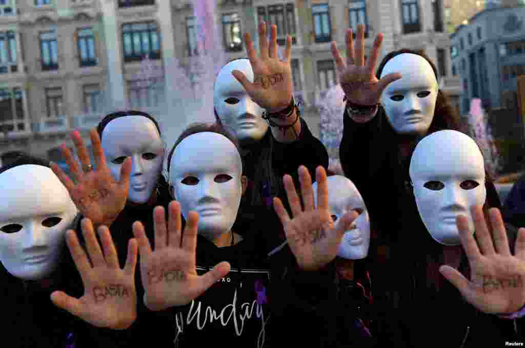 Gender studies students wearing masks pose with the word "Enough" written on their hands during a performance to commemorate victims of gender violence, during the U.N. International Day for the Elimination of Violence against Women, in Oviedo, Spain, Nov. 25, 2016.
