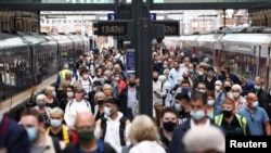 Orang-orang yang memakai masker berjalan di sepanjang peron di Stasiun King's Cross, di tengah wabah COVID-19 di London, Inggris, 12 Juli 2021. (Foto: Reuters)