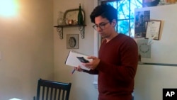 In this March 25, 2020 image taken from video by Caillin Wells, neuroscientist Michael Wells works on the COVID-19 Pandemic Shareable Scientist Response Database in his home in Cambridge, Massachusetts.