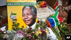 Warga Afrika Selatan meletakkan karangan bunga di depan bekas rumah Nelson Mandela di Soweto, Johannesburg, Afrika Selatan (7/12). 