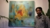 Chhim Sothy, a Cambodian artist, pose in front of his painting at the launching of his exhibition called "Consuming Passion" at the Plantation Hotel in Phnom Penh, Cambodia, on June 25, 2015. 