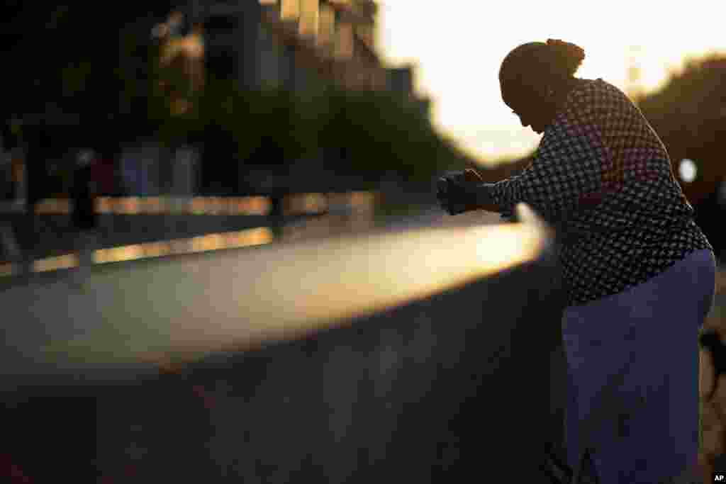 Doris Simmons stands across the street from Emanuel AME Church, the scene of last week's mass shooting, as the sun rises in Charleston, South Carolina. President Barack Obama delivered the eulogy for one of the victims, Sen. Clementa Pinckney, during his funeral Friday at a nearby college arena.