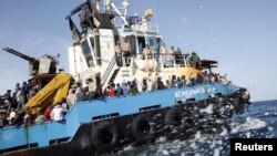 Des migrants Somaliens, Soudanais et Ethiopiens, transportés à bord d’un bateau de l’armée libyenne après avoir été secourus près de la côte de Misrata, Libye, 3 mai 2015. 