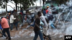 Warga menyelamatkan diri dari gas air mata yang dtembakkan oleh polisi di desa Katwekera, Kenya, 26 Oktober 2017.