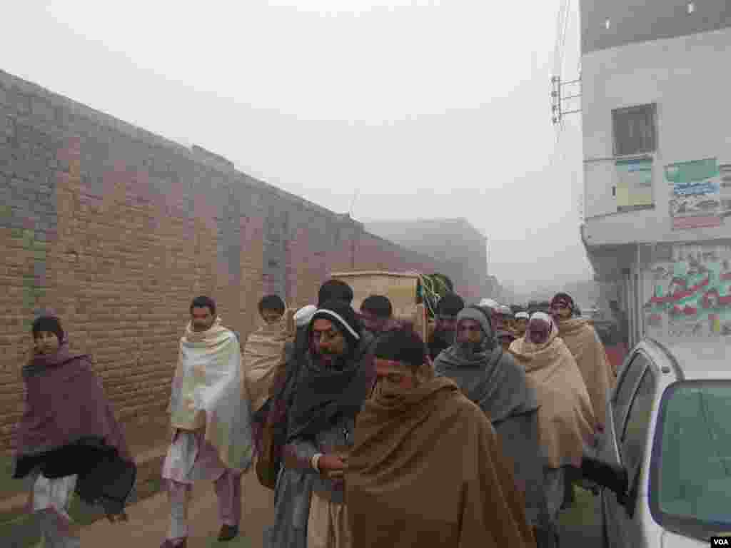 Pakistani mourners bury the victims as the nation prepares for mass funerals for over 140 people, most of them children, killed by the Taliban the day before, Peshawar, Pakistan, Dec. 17, 2014. (VOA)