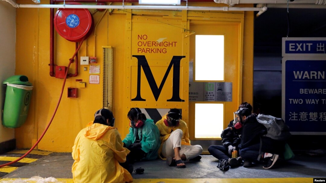香港理工大學的幾名抗議者在地下停車場等候逃走的時機。（2019年11月20日）