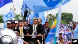រូប​ឯកសារ៖ លោក សម រង្ស៊ី និង​លោក កឹម សុខា ថ្នាក់ដឹកនាំ​នៃ​គណបក្ស​សង្គ្រោះ​ជាតិ​ដែល​ត្រូវ​បាន​រំលាយ ​​ស្វាគមន៍​អ្នក​គាំទ្រ​ក្រោយ​ចេញ​ពី​អាកាសយានដ្ឋាន​អន្តរជាតិ​ភ្នំពេញ កាល​ពី​ថ្ងៃ​ទី​១៩ ខែ​កក្កដា ឆ្នាំ​២០១៣។ (AP)