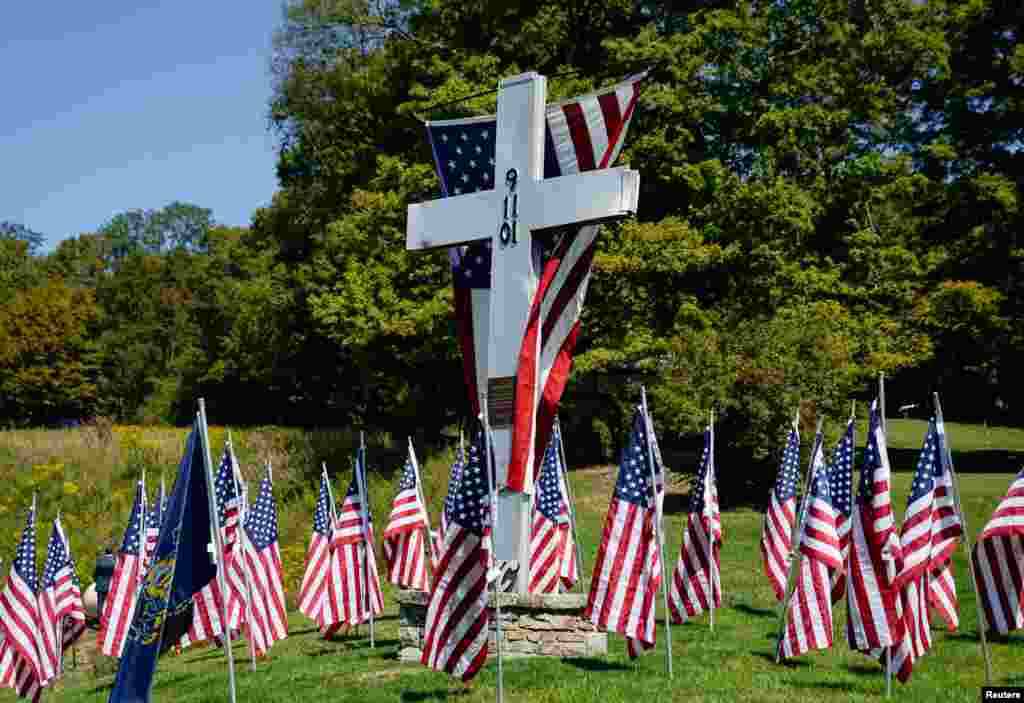 American flags are displayed next to a cross commemorating those killed when hijacked Flight 93 crashed into an open field on Sept. 11, 2001, in Shanksville, Pennsylvania, Sept. 11, 2024.