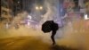 资料照片：2020年元月1日，香港一名抗议者在警方施放催泪弹时撑着雨伞。