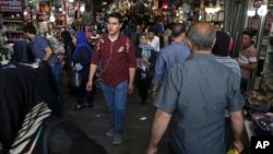 Iranians walk through Tehran's old main bazaar, May 6, 2018. From airplanes to oilfields, billions of dollars are on the line for international corporations as President Donald Trump weighs whether to pull America out of Iran's nuclear deal with world pow