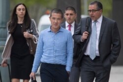FILE - Former Goldman Sachs executive Roger Ng, center, leaves Brooklyn Federal court with attorney Marc Agnifilo, right, May 6, 2019, in New York.