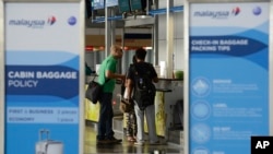 Travelers check in at a Malaysia Airlines counter at Kuala Lumpur International Airport in Sepang, Malaysia, July 18, 2014.