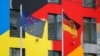 Flags of Germany, right, and the European Union flutter in the wind at the German Embassy in Kyiv, Ukraine, Jan. 24, 2022. 