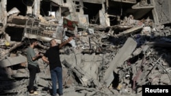 FILE - People stand on the rubble at the site of the Israeli airstrike that killed Lebanon's Hezbollah leader Sayyed Hassan Nasrallah on Friday, in Beirut's southern suburbs, Lebanon, Sept. 29, 2024. 