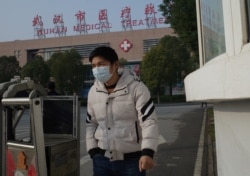 FILE - A man leaves the Wuhan Medical Treatment Center, where a man who died from a respiratory illness was being treated, in the city of Wuhan, Hubei province, China, Jan. 12, 2020.
