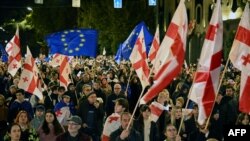 Protesters wave flags during a pro-Europe rally ahead of the parliamentary elections, which are seen as a crucial test for the country's democracy and its bid for EU membership, in Tbilisi on Oct. 20, 2024.