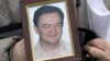 In this Nov. 30, 2009 photo, a portrait of lawyer Sergei Magnitsky who died in jail, is held by his mother Nataliya Magnitskaya, as she speaks during an interview with the AP in Moscow.