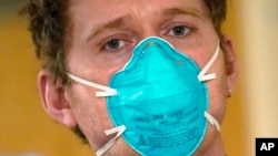 Medicinski tehničar Skot Mekgison nosi masku N95 dok napušta sobu s pacijentima u odeljenju za intenzivnu negu u medicinskom centru Harborvju, u Sijetlu, 14. januara 2022.