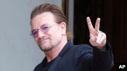 រូបឯកសារ៖ តា​រា​ចម្រៀង​ Bono លើក​សញ្ញា​សន្តិភាព​នៅ​ពេល​លោក​មក​ដល់​ការ​ប្រជុំ​មួយ​នៅ​វិមាន​ Elysee ក្នុង​ទីក្រុង​ប៉ារីស ប្រទេស​បារាំង កាល​ពី​ខែ​កក្កដា។
