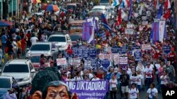 Sebuah boneka yang menggambarkan sosok Presiden Rodrigo Duterte memimpin para pemrotes berbaris menuju Istana Kepresidenan di Manila, Filipina, menandai perayaan Hari Perempuan Internasional, 8 Maret 2018.