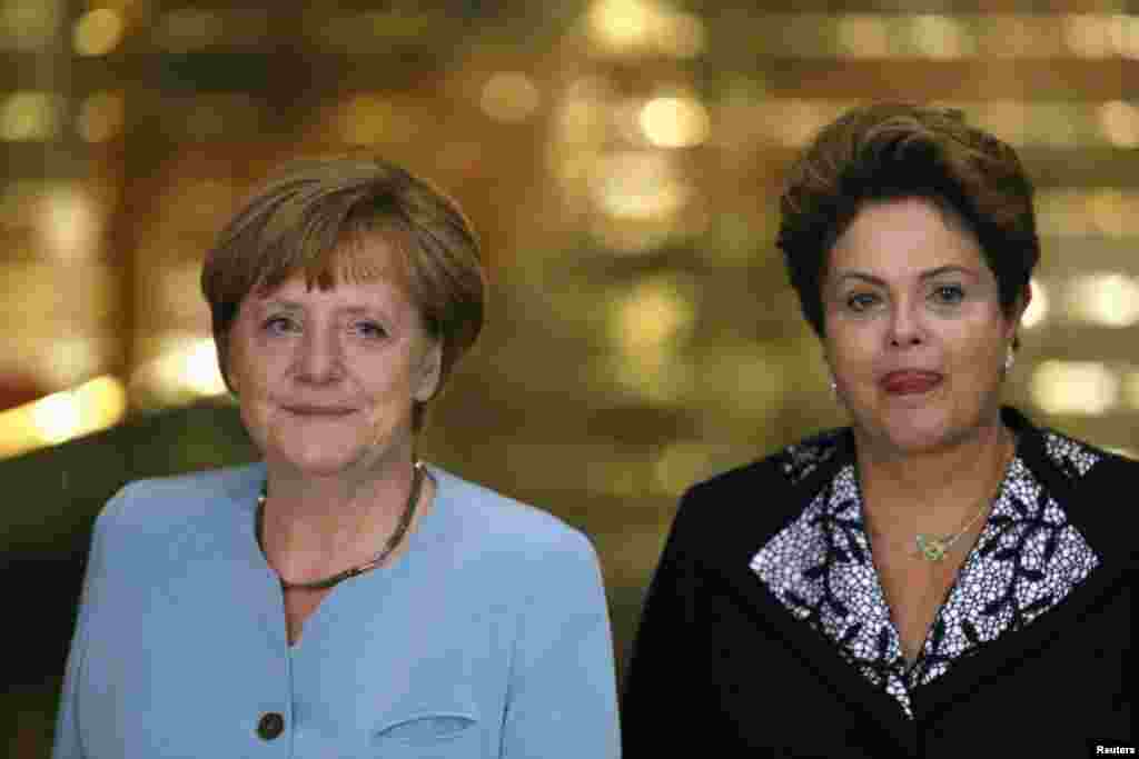 Presiden Brazil Dilma Rousseff (kanan) menyambut Kanselir Jerman Angela Merkel yang berada di Brazil untuk menonton pertandingan Jerman lawan Portugal dalam Piala Dunia di Brasilia (15/6). (Reuters/Ueslei Marcelino)