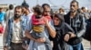 A man, suspected of having collaborated with the Islamic State group, is greetd by family members upon his release from the Kurdish-run Alaya prison in the northeastern Syrian city of Qamishli, on Oct. 15, 2020.