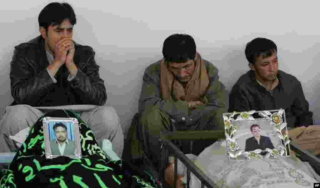 People mourn next to the coffins of their relatives who were killed in bombings, Quetta, Pakistan, January 11, 2013.
