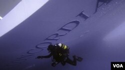 Seorang penyelam menginspeksi kapal Costa Concordia (19/1).