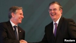 Menteri Luar Negeri AS Antony Blinken (kiri) berjabat tangan dengan Menteri Luar Negeri Meksiko Marcelo Ebrard setelah berbicara kepada awak media sebelum menghadiri pertemuan antara kedua negara di Meksiko City pada 8 Oktober 2021. (Foto: Reuters/Edgard Garrido)