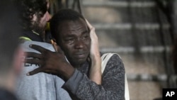 In this photo taken on Tuesday, Aug. 20, 2019 a man cries as he hugs a crew member after disembarking from the Open Arms rescue ship on the Sicilian island of Lampedusa, southern Italy. An Italian prosecutor ordered the seizure of a rescue ship and…