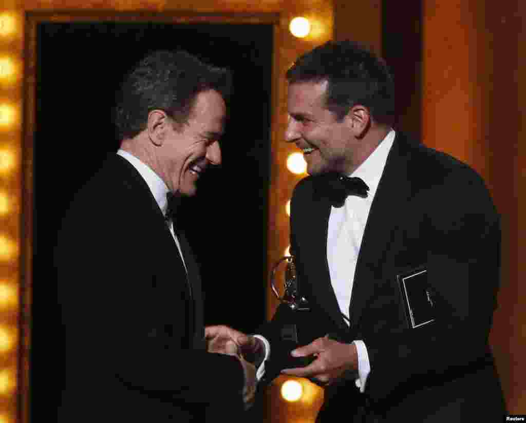 Bradley Cooper (kanan) menyerahkan piala Tony untuk Bryan Cranston, pemeran utama pria terbaik dalam "All The Way" pada malam anugerah untuk insan teater Amerika "Tony Awards" di Radio City Music Hall, New York (8/6).