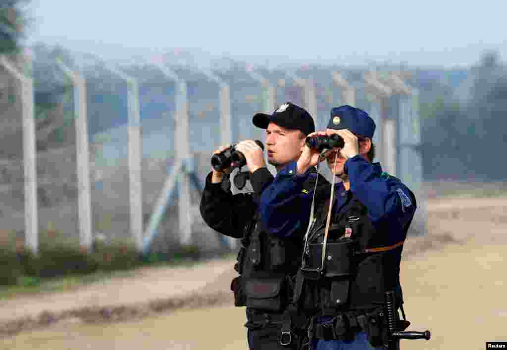 Hungarian and Polish policeman patrol at the Hungary and Serbia border fence near the village of Asotthalom, Oct. 2, 2016 as Hungarians vote in a referendum on the European Union's migrant quotas.