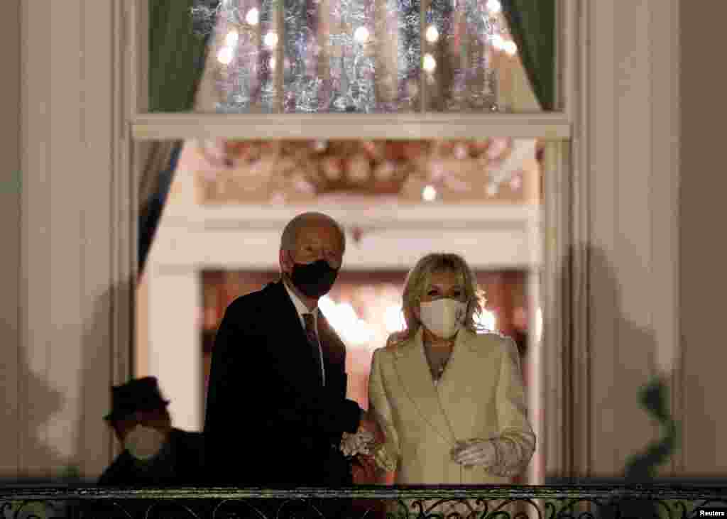 El presidente de Estados Unidos, Joe Biden, y la primera dama Jill Biden, miran los fuegos artificiales desde el balcón de la Casa Blanca después de la toma de posesión como presidente 46 de EE.UU.