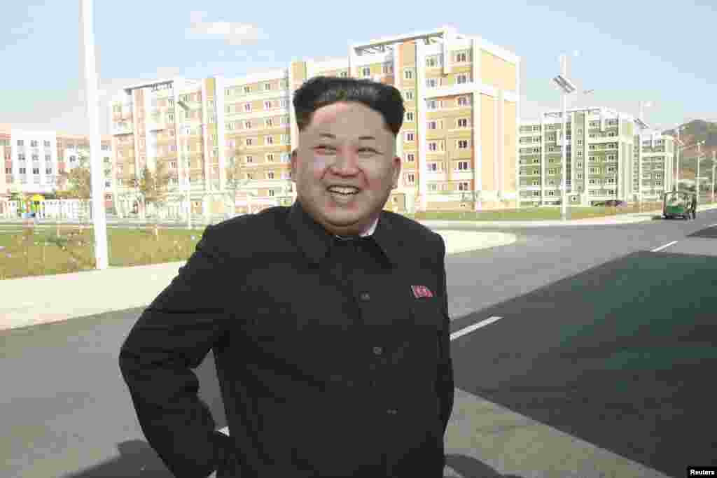 North Korean leader Kim Jong Un poses outside the newly built Wisong Scientists Residential District in this undated photo released by North Korea's Korean Central News Agency (KCNA) in Pyongyang October 14, 2014.