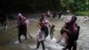 Migrantes caminan con niños en su viaje hacia la frontera con Estados Unidos, en Acandi, Colombia, el 9 de julio de 2023.