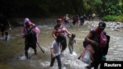 Migrantes caminan con niños en su viaje hacia la frontera con Estados Unidos, en Acandi, Colombia, el 9 de julio de 2023.