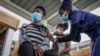 FILE - A nurse gives a shot of AstraZeneca coronavirus vaccine, donated by Denmark, to a woman at Mbagathi Hospital in Nairobi, Kenya, July 9, 2021. 
