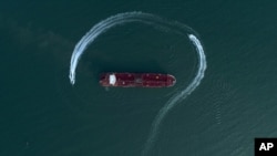 Foto yang diambil dari udara tampak kapal milik Garda Revolusioner Iran bergerak di sekitar kapal tanker berbendera Inggris, Stena Impero, yang disita oleh Garda di Selat Hormuz, di pelabuhan Bandar Abas, Iran, 21 Juli 2019. 