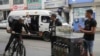 ARCHIVO - El venezolano Maikol Gámez llega en su bicicleta para unirse a sus hermanos Darling y Jhonier para vender café en las calles de Lima, Perú, el 23 de agosto de 2024.