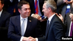 Macedonian Foreign Minister Nikola Dimitrov shakes hands with NATO Secretary-General Jens Stoltenberg during a signature ceremony of the accession protocol between the Republic of North Macedonia and NATO at the Alliance headquarters in Brussels, Feb. 6, 2019. 